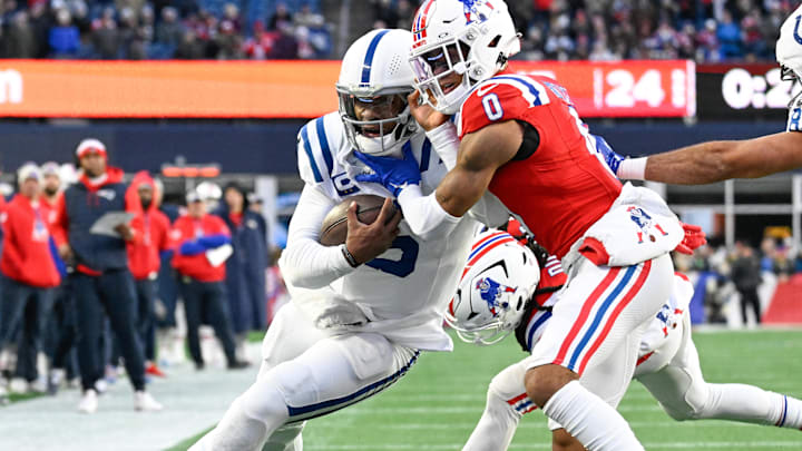 Dec 1, 2024; Foxborough, Massachusetts, USA; New England Patriots cornerback Christian Gonzalez (0) tackles Indianapolis Colts quarterback Anthony Richardson (5) short of the goal line during the second half at Gillette Stadium. Mandatory Credit: Eric Canha-Imagn Images
