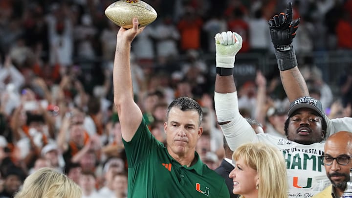 Miami Hurricanes head coach Mario Cristobal holds the Vrbo Fiesta Bowl trophy after their 31-27 win over the Ole Miss Rebels at State Farm Stadium on Jan. 8, 2026.
