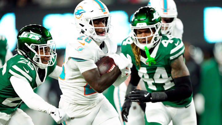 Miami Dolphins running back De'Von Achane (28) scores a touchdown after running past New York Jets cornerback Brandin Echols (26) and New York Jets linebacker Jamien Sherwood.