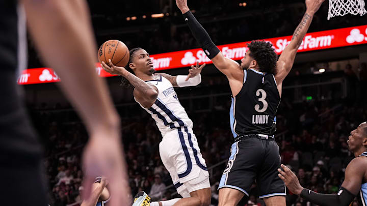 Dec 23, 2023; Atlanta, Georgia, USA; Memphis Grizzlies guard Ja Morant (12) shoots against Atlanta Hawks guard Seth Lundy (3) during the second half  at State Farm Arena. Mandatory Credit: Dale Zanine-Imagn Images