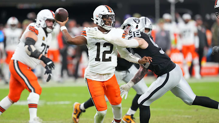 Nov 23, 2025; Paradise, Nevada, USA; Cleveland Browns quarterback Shedeur Sanders (12) looks to make a pass attempt as Las Vegas Raiders defensive end Maxx Crosby (98) tackles him during the third quarter at Allegiant Stadium. Mandatory Credit: Stephen R. Sylvanie-Imagn Images