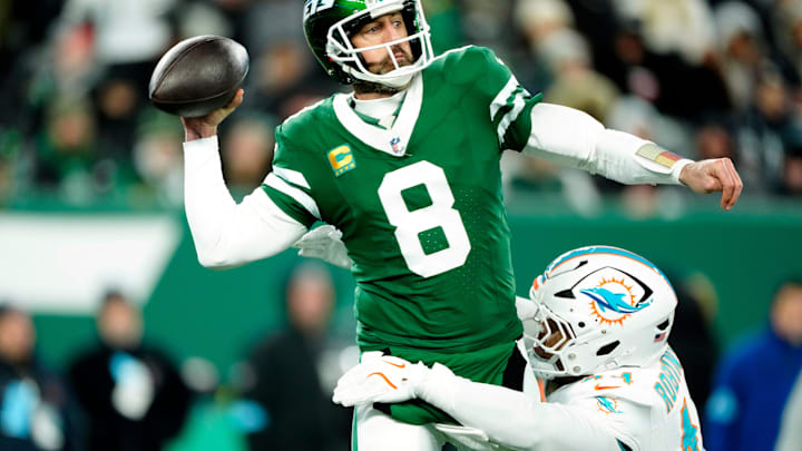 New York Jets quarterback Aaron Rodgers (8) throws a pass before Miami Dolphins linebacker Chop Robinson (44) could take him down, Sunday January 5, 2025, in East Rutherford.