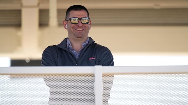 Feb 16, 2024; Goodyear, AZ, USA; Cincinnati Reds President of Baseball Operations Nick Krall smiles as he takes a phone call during spring training workouts. Mandatory Credit: Kareem Elgazzar/The Enquirer-Imagn Images