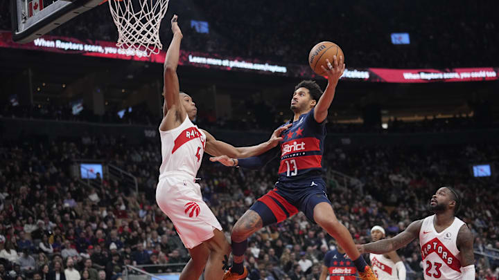 Mar 10, 2025; Toronto, Ontario, CAN; Washington Wizards guard Jordan Poole (13) goes up to make a basket as Toronto Raptors guard Scottie Barnes (4) defends during the first half at Scotiabank Arena. Mandatory Credit: John E. Sokolowski-Imagn Images