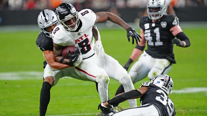 Dec 16, 2024; Paradise, Nevada, USA; Atlanta Falcons tight end Kyle Pitts (8) is tackled by Las Vegas Raiders safety Isaiah Pola-Mao (20) and Las Vegas Raiders cornerback Nate Hobbs (39) during the third quarter at Allegiant Stadium. Mandatory Credit: Stephen R. Sylvanie-Imagn Images