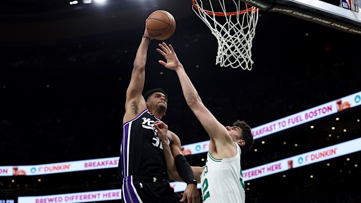 Jan 30, 2026; Boston, Massachusetts, USA; Sacramento Kings center Dylan Cardwell (32) goes in for a dunk over Boston Celtics center Luka Garza (52) during the first quarter at TD Garden. Mandatory Credit: Winslow Townson-Imagn Images