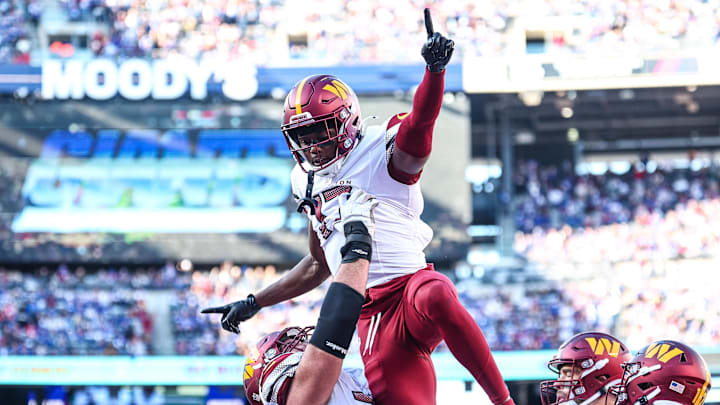 Nov 3, 2024; East Rutherford, New Jersey, USA;  Washington Commanders wide receiver Terry McLaurin (17) celebrates after a touchdown reception with guard Sam Cosmi (76) during the first half against the New York Giants at MetLife Stadium. Mandatory Credit: Vincent Carchietta-Imagn Images