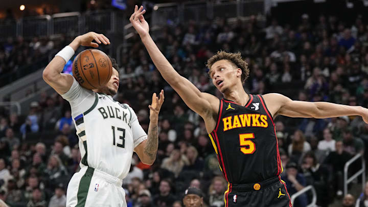 Mar 30, 2025; Milwaukee, Wisconsin, USA;  Atlanta Hawks guard Dyson Daniels (5) and Milwaukee Bucks guard Ryan Rollins (13) reach for the loose ball during the third quarter at Fiserv Forum. Mandatory Credit: Jeff Hanisch-Imagn Images