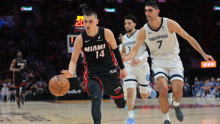 Apr 3, 2025; Miami, Florida, USA; Miami Heat guard Tyler Herro (14) dribbles the basketball past Memphis Grizzlies forward Santi Aldama (7) during the fourth quarter at Kaseya Center. Mandatory Credit: Sam Navarro-Imagn Images