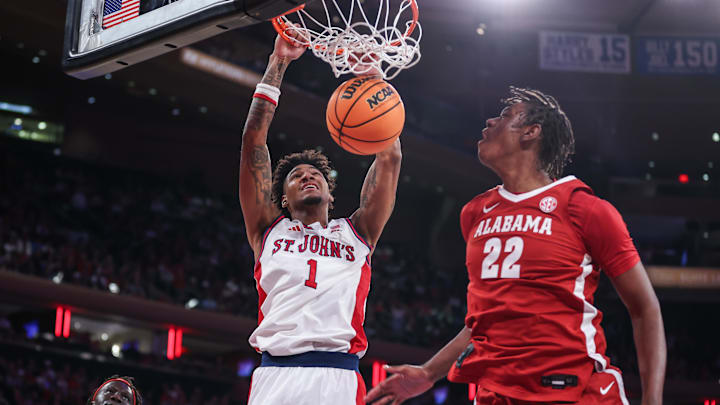 Nov 8, 2025; New York, New York, USA; St. John's basketball forward Dillon Mitchell (1) dunks past Alabama Crimson Tide forward Aiden Sherrell (22) in the second half at Madison Square Garden.