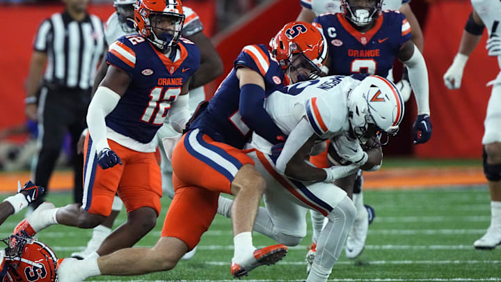 Syracuse Orange linebacker Justin Barron tackles Virginia Cavaliers wide receiver Keytaon Thompson.