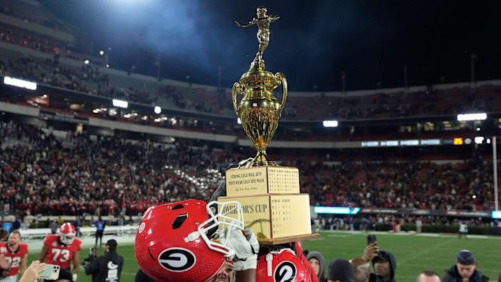 Georgia offensive lineman Tate Ratledge (69) raises the governor cup after Georgia won a NCAA college football game against Georgia Tech in overtime in Athens, Ga., on Friday, Nov. 29, 2024. Georgia won 44-42.