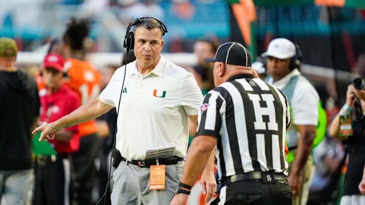 Nov 8, 2025; Miami Gardens, Florida, USA; Miami Hurricanes head coach Mario Cristobal talks to an official during a timeout in a game against the Syracuse Orange during the second quarter at Hard Rock Stadium. Mandatory Credit: Jeff Romance-Imagn Images Nov 8, 2025; Miami Gardens, Florida, USA; Miami Hurricanes head coach Mario Cristobal talks to an official during a timeout in a game against the Syracuse Orange during the second quarter at Hard Rock Stadium. Mandatory Credit: Jeff Romance-Imagn Images