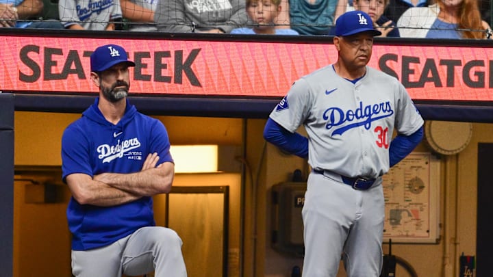 Aug 15, 2024; Milwaukee, Wisconsin, USA; Los Angeles Dodgers manager Dave Roberts (right) and pitching coach Mark Prior look on from the dugout in the seventh inning against the Milwaukee Brewers at American Family Field. Mandatory Credit: Benny Sieu-Imagn Images