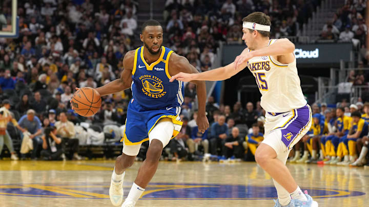 Dec 25, 2024; San Francisco, California, USA; Golden State Warriors forward Andrew Wiggins (22) dribbles against Los Angeles Lakers guard Austin Reaves (15) during the third quarter at Chase Center. Mandatory Credit: Darren Yamashita-Imagn Images