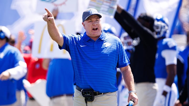 Aug 30, 2025; Lexington, Kentucky, USA; Kentucky Wildcats head coach Mark Stoops discusses a play with a referee during the first quarter against the Toledo Rockets at Kroger Field. Mandatory Credit: Jordan Prather-Imagn Images