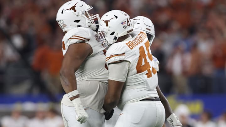 Jan 10, 2025; Arlington, Texas, USA; Texas Longhorns defensive lineman Alfred Collins (95) and defensive lineman Vernon Broughton (45) celebrate after a sack during the third quarter of the College Football Playoff semifinal against the Ohio State Buckeyes in the Cotton Bowl at AT&T Stadium. Mandatory Credit: Tim Heitman-Imagn Images