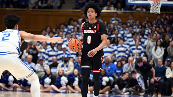 Jan 26, 2026; Durham, North Carolina, USA; Louisville Cardinals guard Mikel Brown Jr. (0) dribbles up court as Duke Blue Devils guard Cayden Boozer (2) defends during the first half at Cameron Indoor Stadium. Mandatory Credit: Rob Kinnan-Imagn Images