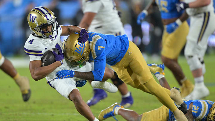 Nov 22, 2025; Pasadena, California, USA; Washington Huskies running back Jordan Washington (4) is stopped by UCLA Bruins defensive back Aaron Williams (7) after a gain of 17 yards and a first down during the second half at the Rose Bowl. Mandatory Credit: Jayne Kamin-Oncea-Imagn Images Nov 22, 2025; Pasadena, California, USA; Washington Huskies running back Jordan Washington (4) is stopped by UCLA Bruins defensive back Aaron Williams (7) after a gain of 17 yards and a first down during the second half at the Rose Bowl. Mandatory Credit: Jayne Kamin-Oncea-Imagn Images