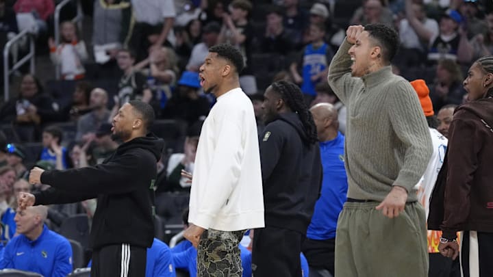 Apr 13, 2025; Milwaukee, Wisconsin, USA; Milwaukee Bucks guard Damian Lillard (0), Milwaukee Bucks forward Giannis Antetokounmpo (34) and Milwaukee Bucks forward Kyle Kuzma (18) celebrate as the Milwaukee Bucks defeat the Detroit Pistons in overtime at Fiserv Forum. Mandatory Credit: Michael McLoone-Imagn Images