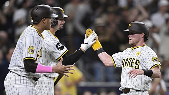 Jun 25, 2024; San Diego, California, USA; San Diego Padres second baseman Jake Cronenworth (right) is congratulated by center fielder Jackson Merrill (center) and third baseman Manny Machado (13) after scoring a run against the Washington Nationals during the fifth inning at Petco Park. 