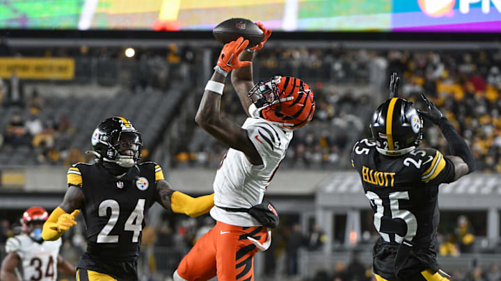 Jan 4, 2025; Pittsburgh, Pennsylvania, USA; Cincinnati Bengals wide receiver Tee Higgins (5) catches a pass in front of Pittsburgh Steelers cornerback Joey Porter Jr. (24) and safety DeShon Elliott (25) during the second quarter at Acrisure Stadium. Mandatory Credit: Barry Reeger-Imagn Images