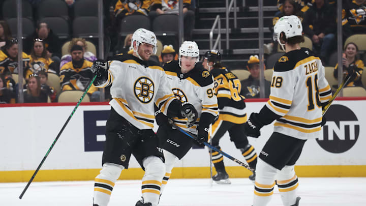 Apr 13, 2025; Pittsburgh, Pennsylvania, USA;  Boston Bruins center Jakub Lauko (94) celebrates his empty net goal with center Fraser Minten (93) and center Pavel Zacha (18)  against the Pittsburgh Penguins during the third period at PPG Paints Arena. Mandatory Credit: Charles LeClaire-Imagn Images