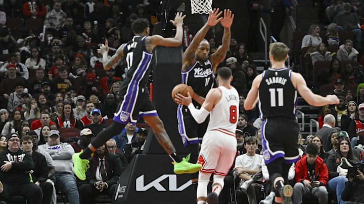Jan 12, 2025; Chicago, Illinois, USA;  Sacramento Kings guard Malik Monk (0) and  forward DeMar DeRozan (10) block Chicago Bulls guard Zach LaVine (8) during the second half at United Center. Mandatory Credit: Matt Marton-Imagn Images