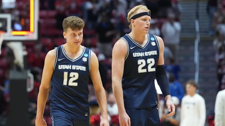 Mar 22, 2026; San Diego, CA, USA; Utah State Aggies guard Mason Falslev (12) and forward Karson Templin (22) react after a loss against the Arizona Wildcats during a second round game of the men's 2026 NCAA Tournament at Viejas Arena. Mandatory Credit: Kirby Lee-Imagn Images