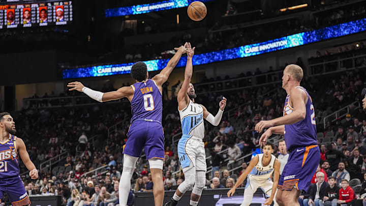 Jan 14, 2025; Atlanta, Georgia, USA; Atlanta Hawks guard Trae Young (11) shoots over Phoenix Suns forward Ryan Dunn (0) during the first half at State Farm Arena. Mandatory Credit: Dale Zanine-Imagn Images