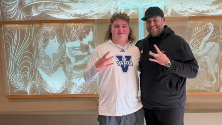 Reis Russell and UW line coach Michael Switzer share a recruiting moment.