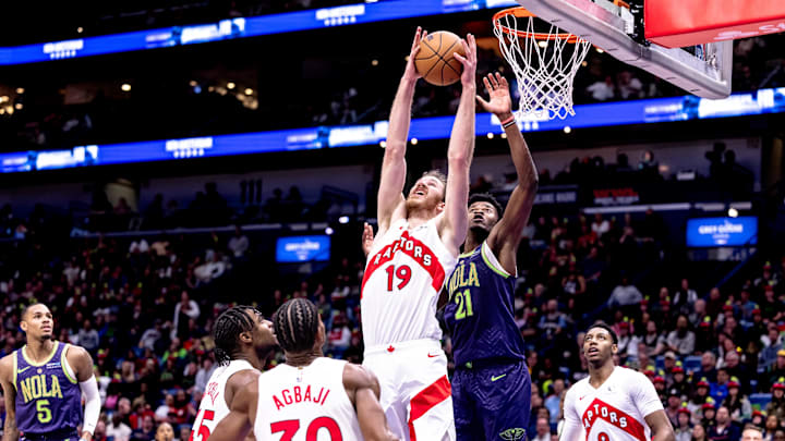 Nov 27, 2024; New Orleans, Louisiana, USA;  Toronto Raptors center Jakob Poeltl (19) grabs a rebound against New Orleans Pelicans center Yves Missi (21) during the first half at Smoothie King Center. Mandatory Credit: Stephen Lew-Imagn Images