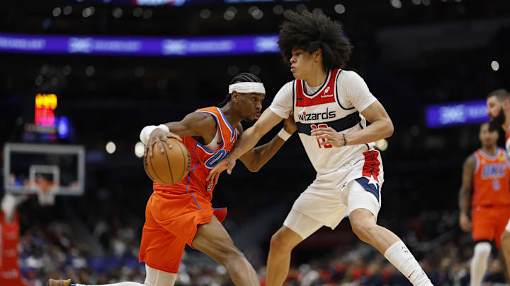 Jan 12, 2025; Washington, District of Columbia, USA; Oklahoma City Thunder guard Shai Gilgeous-Alexander (2) dribbles the ball as Washington Wizards forward Kyshawn George (18) defends in the third quarter at Capital One Arena. Mandatory Credit: Geoff Burke-Imagn Images