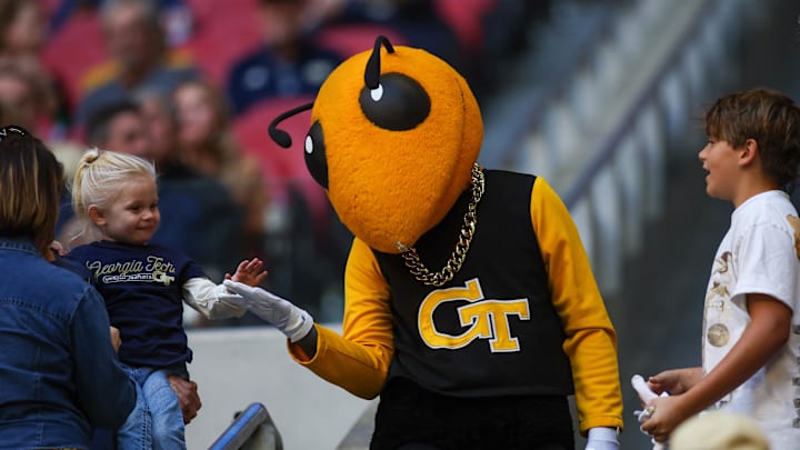 Oct 19, 2024; Atlanta, Georgia, USA; Georgia Tech Yellow Jackets mascot Buzz interacts with a fan against the Notre Dame Fighting Irish in the second quarter at Mercedes-Benz Stadium. Mandatory Credit: Brett Davis-Imagn Images
