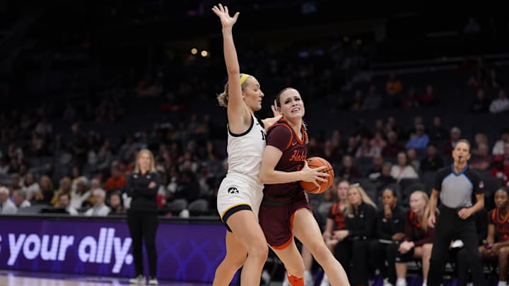 Nov 10, 2024; Charlotte, NC, USA; Iowa Hawkeyes guard Kylie Feuerbach (4) guards Virginia Tech Hokies guard Carleigh Wenzel (1) as she drives to the basket during the second half at Spectrum Center. Mandatory Credit: Jim Dedmon-Imagn Images