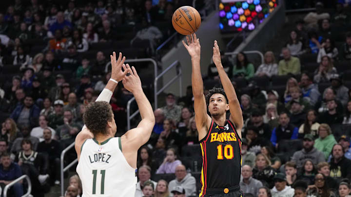 Mar 30, 2025; Milwaukee, Wisconsin, USA;  Atlanta Hawks forward Zaccharie Risacher (10) shoots over Milwaukee Bucks center Brook Lopez (11) during the fourth quarter at Fiserv Forum. Mandatory Credit: Jeff Hanisch-Imagn Images