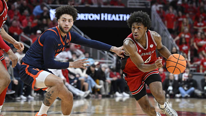 Jan 13, 2026; Louisville, Kentucky, USA;  Louisville Cardinals guard Adrian Wooley (14) dribbles against Virginia Cavaliers guard Sam Lewis (5) during the second half at KFC Yum! Center. Virginia defeated Louisville 79-70. Mandatory Credit: Jamie Rhodes-Imagn Images