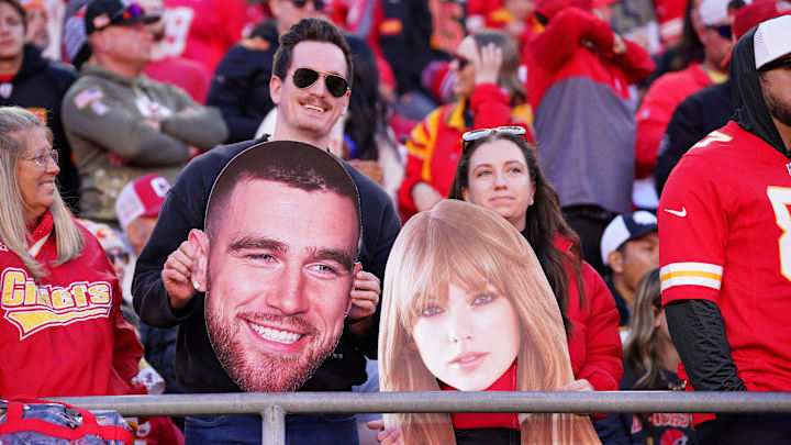Nov 10, 2024; Kansas City, Missouri, USA; Kansas City Chiefs fans hold fathead signs of Travis Kelce (not pictured) and Taylor Swift during the second half of the game against the Denver Broncos at GEHA Field at Arrowhead Stadium. Mandatory Credit: Denny Medley-Imagn Images Nov 10, 2024; Kansas City, Missouri, USA; Kansas City Chiefs fans hold fathead signs of Travis Kelce (not pictured) and Taylor Swift during the second half of the game against the Denver Broncos at GEHA Field at Arrowhead Stadium. Mandatory Credit: Denny Medley-Imagn Images