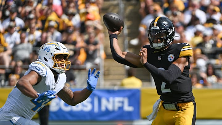 Sep 22, 2024; Pittsburgh, Pennsylvania, USA; Pittsburgh Steelers quarterback Justin Fields (2) throws a pass while under pressure from Los Angeles Chargers linebacker Tuli Tuipulotu (45) during the first quarter at Acrisure Stadium. Mandatory Credit: Barry Reeger-Imagn Images