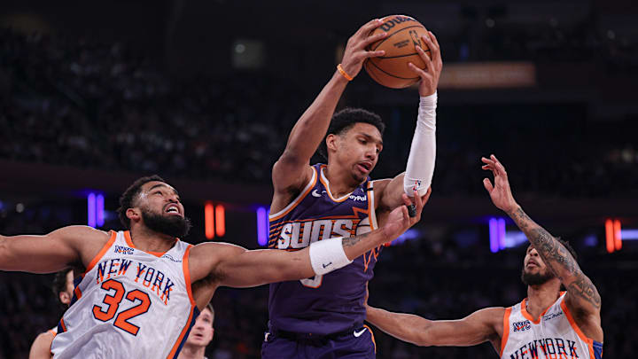 Apr 6, 2025; New York, New York, USA; Phoenix Suns forward Ryan Dunn (0) rebounds against New York Knicks center Karl-Anthony Towns (32) and guard Cameron Payne (1) during the first half at Madison Square Garden. Mandatory Credit: Vincent Carchietta-Imagn Images