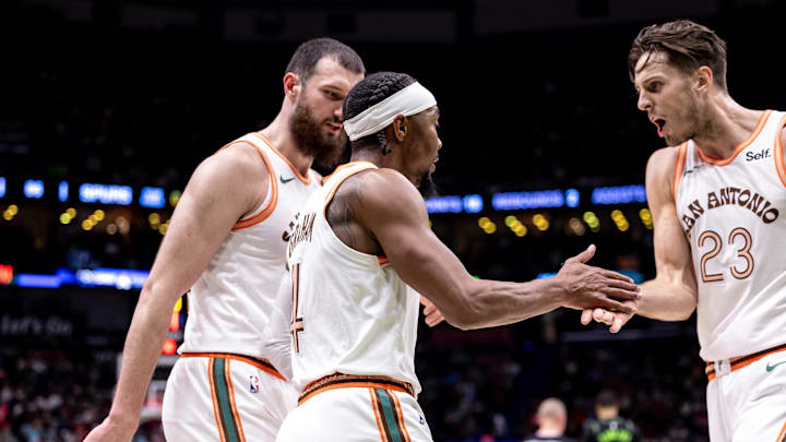 Apr 5, 2024; New Orleans, Louisiana, USA; San Antonio Spurs guard Devonte' Graham (4) slaps hands with forward Zach Collins (23) against the New Orleans Pelicans during the second half at Smoothie King Center. Mandatory Credit: Stephen Lew-Imagn Images