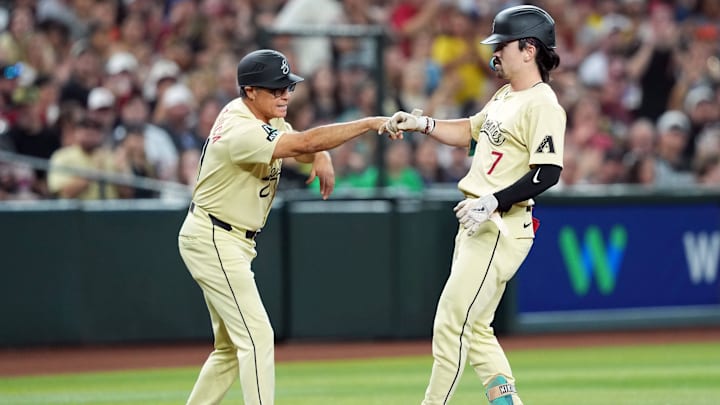 Jun 11, 2024; Phoenix, Arizona, USA; Arizona Diamondbacks outfielder Corbin Carroll (7) bumps fists with Arizona Diamondbacks third base coach Tony Perezchica (21) after hitting an RBI triple against the Los Angeles Angels during the second inning at Chase Field. Mandatory Credit: Joe Camporeale-Imagn Images