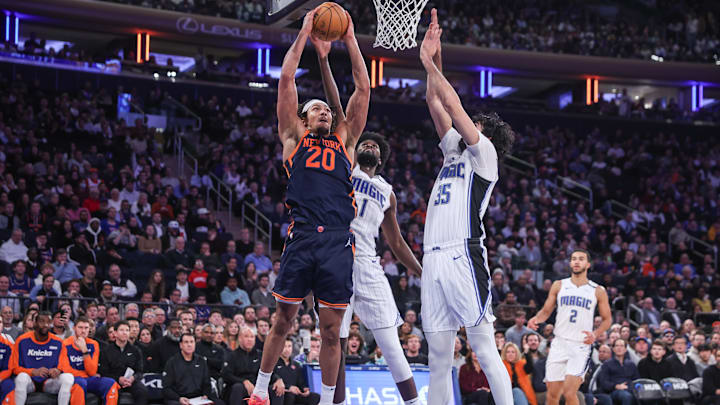 Jan 6, 2025; New York, New York, USA;  New York Knicks center Jericho Sims (20) attempts to dunk past Orlando Magic forward Jonathan Isaac (1) and center Goga Bitadze (35) in the second quarter at Madison Square Garden. Mandatory Credit: Wendell Cruz-Imagn Images