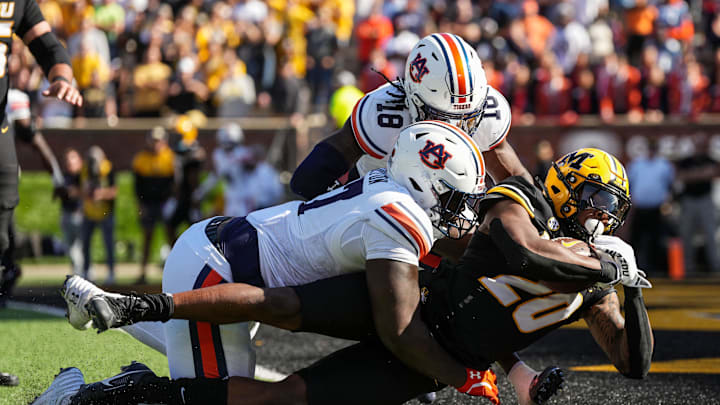 Oct 19, 2024; Columbia, Missouri, USA; Missouri Tigers running back Jamal Roberts (20) scores a touchdown against Auburn Tigers cornerback Mac McClinton (27) and safety Kaleb Harris (18) during the second half at Faurot Field at Memorial Stadium. Mandatory Credit: Jay Biggerstaff-Imagn Images