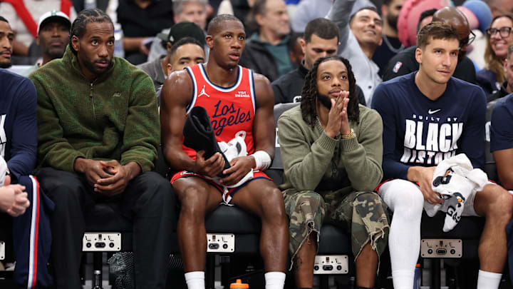 Feb 26, 2026; Inglewood, California, USA;   Los Angeles Clippers forward Kawhi Leonard (left) and guard Darius Garland (second from right) watch a game from the bench during the first half against the Minnesota Timberwolves at Intuit Dome. Mandatory Credit: Kiyoshi Mio-Imagn Images