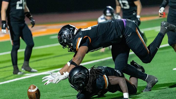 Desert Edge Scorpions Yahzeen Zion (93) jumps over Marshawn Coleman (9) to get to the ball during a game against the Millennium Tigers at Desert Edge High School in Goodyear on Oct. 31, 2025.