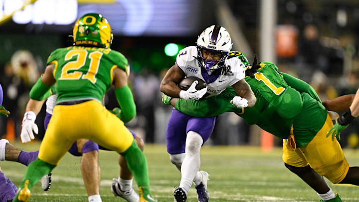 Dec 20, 2025; Eugene, OR, USA;  James Madison Dukes running back Wayne Knight (3) rushes as Oregon Ducks defensive back Aaron Flowers (21) defends during the second quarter at Autzen Stadium. Mandatory Credit: Troy Wayrynen-Imagn Images