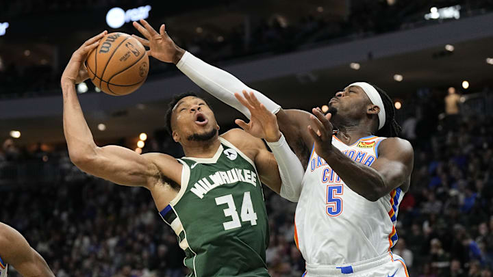 Mar 24, 2024; Milwaukee, Wisconsin, USA;  Milwaukee Bucks forward Giannis Antetokounmpo (34) and Oklahoma City Thunder forward Luguentz Dort (5) reach for a rebound during the third quarter at Fiserv Forum. Mandatory Credit: Jeff Hanisch-Imagn Images