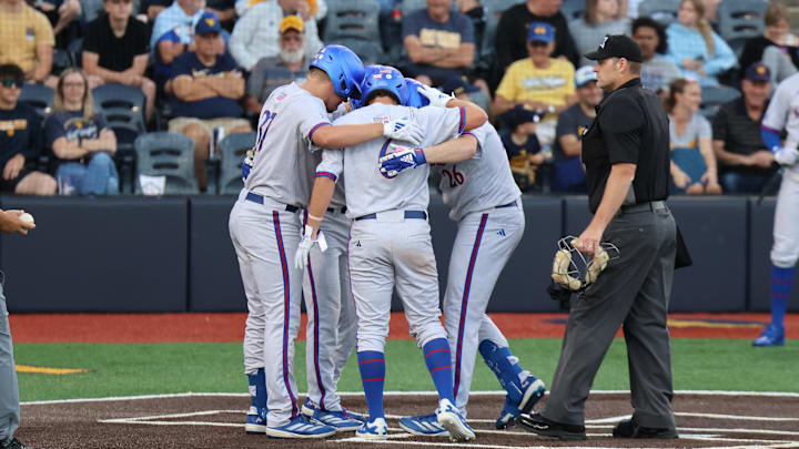 Kansas infielder Brady Ballinger (26) is greeted by teammates after a three-run home run in the fourth inning.