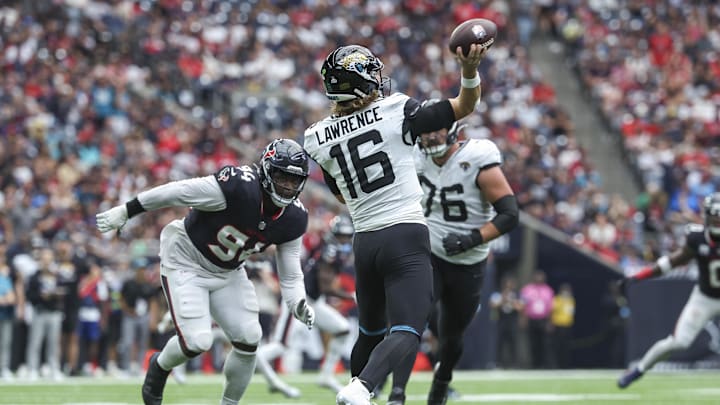 Sep 29, 2024; Houston, Texas, USA; Jacksonville Jaguars quarterback Trevor Lawrence (16) attempts a pass as Houston Texans defensive tackle Khalil Davis (94) applies defensive pressure at NRG Stadium. 